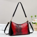 Detail der rot-schwarzen Schlangenhaut-Struktur dieser Boston Bag mit Gold-Hardware - Rot