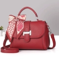 Detail of red lychee grain leather handbag with silver lock and silk scarf on handle - Red