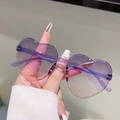 Dettaglio di occhiali da sole a cuore senza montatura con lenti sfumate viola-rosa e aste - Sfumatura Viola Rosa