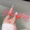 Detailed macro view of pink heart-shaped frameless sunglasses with translucent texture - Gradient Pink
