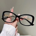 Dettaglio delle stanghette in metallo dorato traforato su occhiali cat-eye neri - Montatura Nera Lente Trasparente