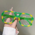 Dettaglio degli occhiali quadrati sfumati giallo e verde in mano per mostrare il materiale acetato - Marmo Verde-Giallo (Lenti Trasparenti)