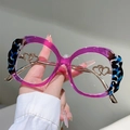 Dettaglio di occhiali rotondi con montatura viola e decoro a cuore in metallo sull'asta - Leopardo Blu Con Viola Trasparente