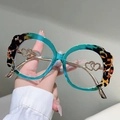 Dettaglio montura occhiali verde acqua e tartaruga con cerniere dorate a doppio cuore - Stampa Leopardata Con Blu Trasparente