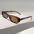 Side view of retro oval tortoiseshell sunglasses with brown lenses on a white pedestal - Leopard Frame / Tea Lens