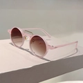 Détail de lunettes de soleil rondes vintage roses avec double pont sur socle en pierre - Monture Rose Dégradé Thé
