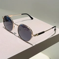 Detail einer runden Vintage-Sonnenbrille mit goldenem Metallrahmen und grauen Gläsern - Goldrahmen Schwarzgrau