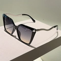 Dettaglio occhiali da sole cat-eye con stanghette a serpente in argento e lenti sfumate - Montatura Nera Lenti Viola e Tè Stanghette Argento