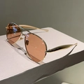 Detail of rose gold aviator sunglasses with brown gradient lenses on a minimalist stand - Gold Frame Tea Lens