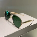 Close-up of classic aviator sunglasses with gold metal frame and dark lenses - Gold Frame Green