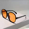 Detailed close-up of oversized round sunglasses with black frames and vibrant orange lenses - Black Frame Orange Lens