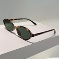Gros plan de lunettes de soleil ovales rétro avec monture écaille et verres vert foncé - Monture Léopard Verres Verts