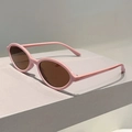 Vue latérale de lunettes de soleil ovales rétro roses avec verres bruns sur socle gris - Monture Rose Verres Thé