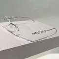 Detailed view of oval rimless glasses with silver metal temples and pearl embellishments - Silver Frame Clear Lens