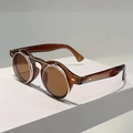 Gedetailleerde close-up van retro flip-up zonnebril met ronde amberkleurige glazen - Transparante Thee Frame Thee Lenzen