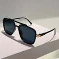 Detailed close-up of square black sunglasses with golden metal accents and grey lenses - Black Frame / Black Lens