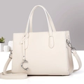 Détail du sac à main beige texture litchi avec pendentif C argenté et bandoulière - Blanc Cassé