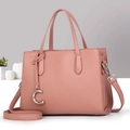 Sac à main en cuir rose poudré avec bandoulière et pendentif C argent sur fond gris - Rose Poudré