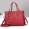 Detailed shot of a red lychee texture leather tote with silver C-pendant and shoulder strap - Red