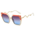 Oversized zonnebril in gebroken wit met goudkleurige slangenpoten en gradiënt glazen - Beige en Oranje Montuur Blauwgrijze Lens