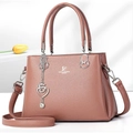 Pink faux leather tote bag with heart charm and David Jones Paris logo on gray background - Pink