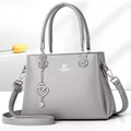 Elegant grey pebbled leather handbag with silver S-heart charm and crossbody strap - Gray