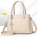 Détail du sac à main en similicuir beige avec logo David Jones et pendentif cœur - Abricot