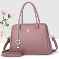 Detail view of pink leather crossbody bag with silver logo and cute cat charm - Purple