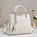 Close-up of white lychee leather texture and silver star charm on the tote bag - Off White