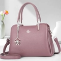 Close-up of violet lychee pattern leather handbag with silver hardware and floral charm - Purple