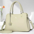 Detail of light green pebbled leather handbag featuring floral charm and brand logo - Green