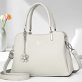 Detailed macro view of white lychee pattern leather bag with floral charm and silver logo - Gray