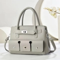 Detailed view of grey pebble leather handbag with silver twist lock and twin front pockets - Gray