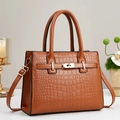 Detailed view of brown crocodile texture handbag featuring golden turn-lock closure - Khaki/Earth Yellow