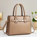 Detailed close-up of beige crocodile embossed handbag with gold hardware and top handle - Khaki