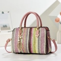Colorful striped woven handbag with pink leather straps and a gold pearl leaf charm - Pink