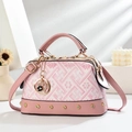 Borsa rosa floreale con borchie dorate e ciondolo a cuore in ambiente minimal - Rosa