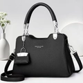 Detail of black lychee grain leather handbag with silver hardware and mini charm - Black