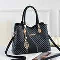 Fashionable black tote bag with DH pattern and gold logo in a stylish room setting - Black