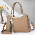 Detail of tan pebble leather tote bag with silver metal bar handle and cord charm - Dark Khaki