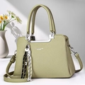 Detail of pistachio green pebble leather handbag with silver hardware and pendant - Green