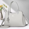 Detail of grey pebbled leather handbag featuring silver hardware and brand logo - Gray