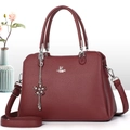 Détail du sac à main bordeaux grainé avec logo argenté et breloque fleur élégante - Bordeaux