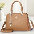 Detailed macro view of brown pebbled leather texture and silver brand logo on tote bag - Yellow