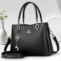 Détail du sac bandoulière noir avec breloque fleur et logo de la marque - Noir
