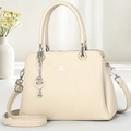 Détail du sac beige avec texture grainée et pendentif en forme de cœur argenté chic - Abricot