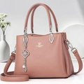 Pink faux leather handbag with adjustable strap and metal charm for women - Pink