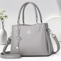 Detail of grey lychee textured leather bag with silver David Jones Paris logo and floral charm - Gray