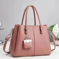 Detailed shot of pink pebble grain leather handbag with mini kelly-style bag charm - Pink
