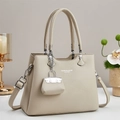 Borsa tote beige in pelle martellata con tracolla e piccolo ciondolo accessorio - Albicocca